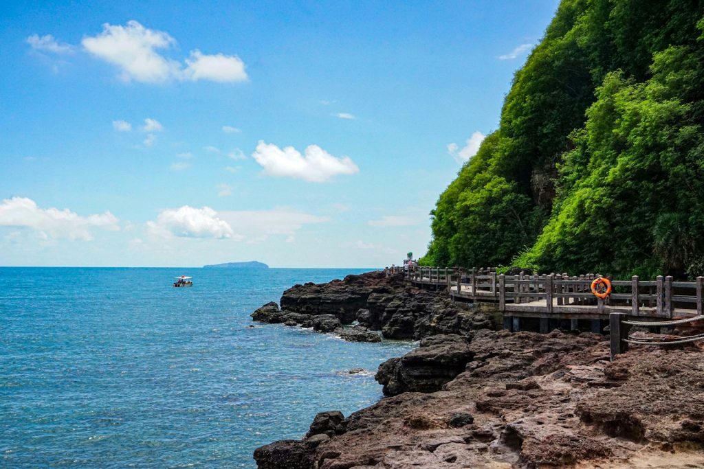 a boat is on the water near a rocky shore