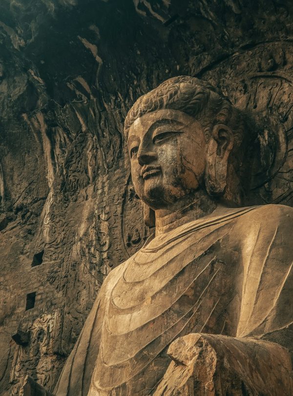 a large statue of a buddha in a cave