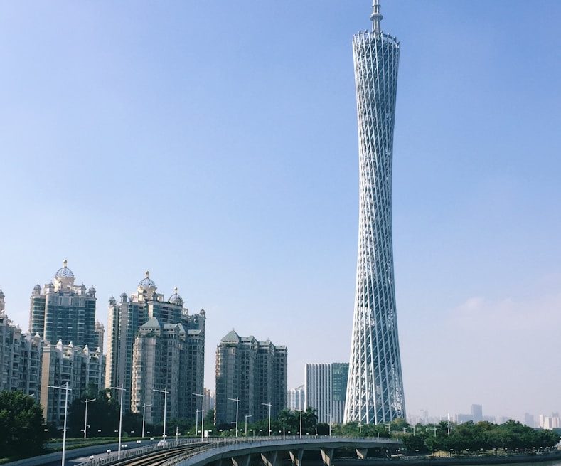 a very tall tower towering over a city next to a river